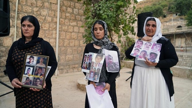 أيزيديات يرفعن في الثاني من آب (أغسطس) صور ضحايا المذبحة التي نفذتها داعش بحق أهالي سنجار في عام 2014