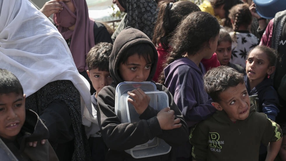 أطفال ينتظرون دورهم للحصول على طعام في مدينة رفح بجنوب قطاع غزة في 28 شباط/فبراير 2024