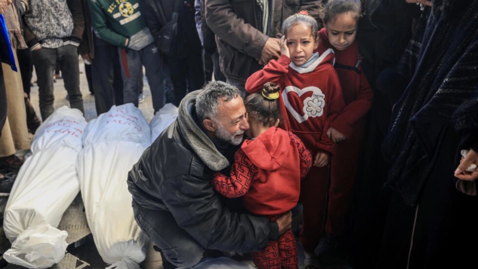 رجل يحتضن طفلة صغيرة في مستشفى نجار في رفح في 8 شباط (فبراير) 2024 بعد تعرفه على جثث أقارب له قتلوا في قصف إسرائيلي على جنوب قطاع غزة 