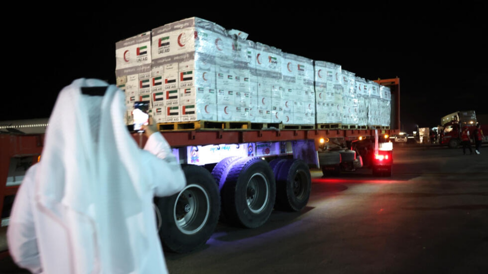 مسؤول إماراتي يلتقط صورة لشاحنة تحمل حزم مساعدات إماراتية لدى وصولها إلى مطار العريش الدولي المصري في 17 تشرين الثاني (نوفمبر) 2023