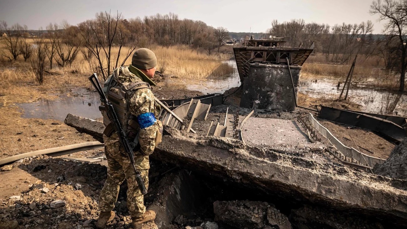 جندي أوكراني يقوم بدورية بالقرب من جسر دمره الجيش الروسي في بلدة روغان شرق خاركيف