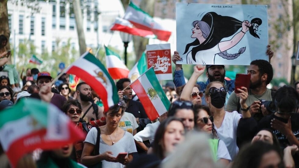 أشخاص يرفعون لافتات وأعلامًا إيرانية خلال تظاهرة في نيويورك تضامنًا مع النساء الإيرانيات في 16 أيلول/سبتمبر 2023 في الذكرى الأولى لوفاة الشابة مهسا أميني