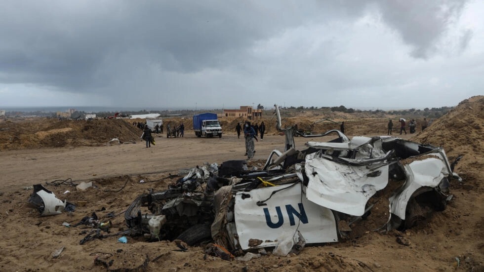 فلسطينيون يسيرون إلى جانب مركبة مدمّرة تابعة للأمم المتحدة بعد عودتهم لبعض الوقت إلى مدينة خان يونس بجنوب قطاع غزة لتفقد ما بقي من منازلهم، في السابع من آذار/مارس 2024