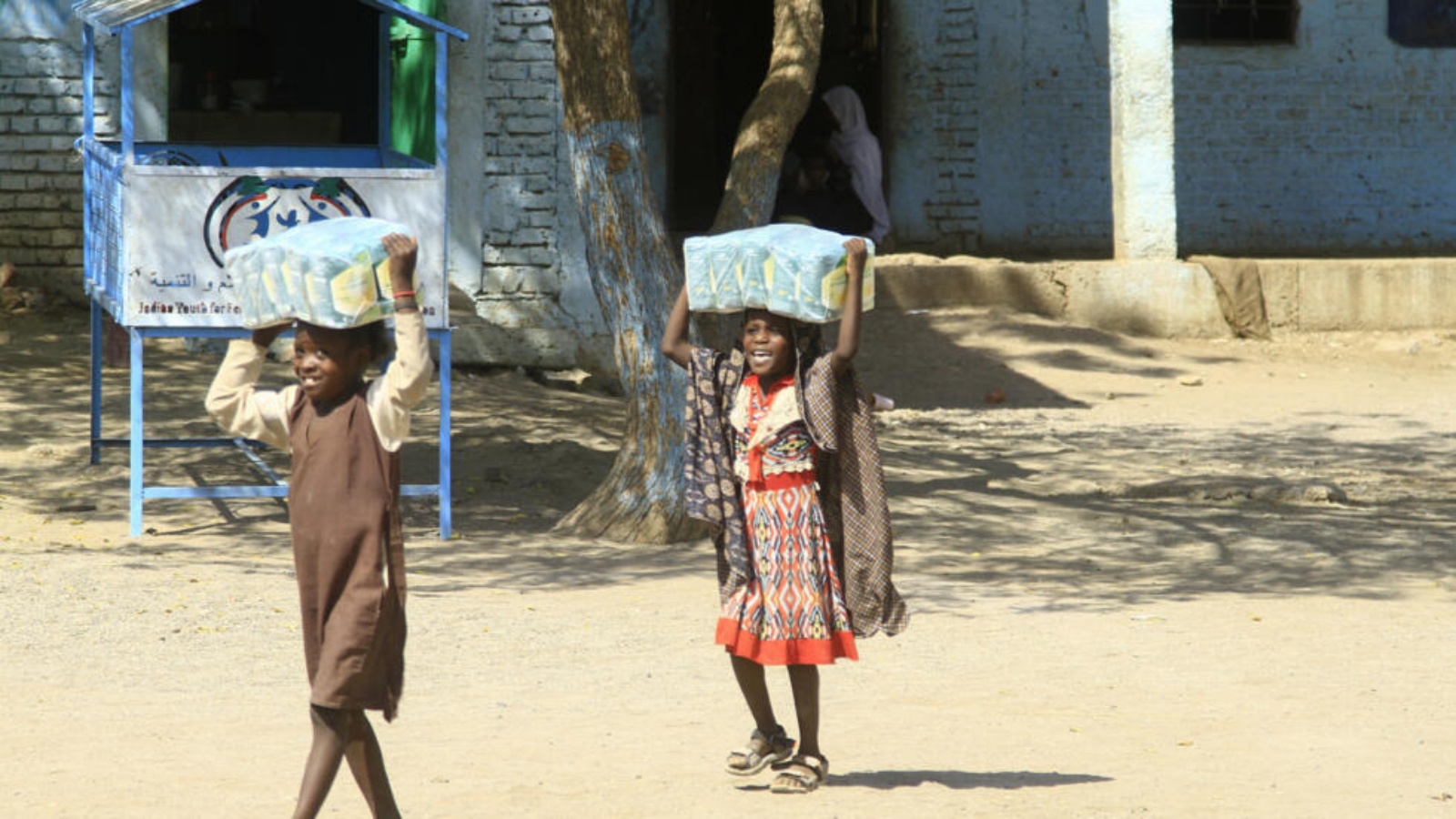 أطفال سودانيون يحملون مساعدات غذائية في مدرسة تضم نازحين قرب القضارف في السودان. 6 آذار (مارس) 2024 
