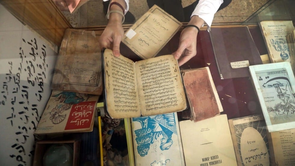 عضو في مركز كردستان للفنون والثقافة يفحص كتبا قديمة قبل حفظها الكترونيا في مكتبة دهوك في اقليم كردستان في شمال العراق في 13 فبراير 2024