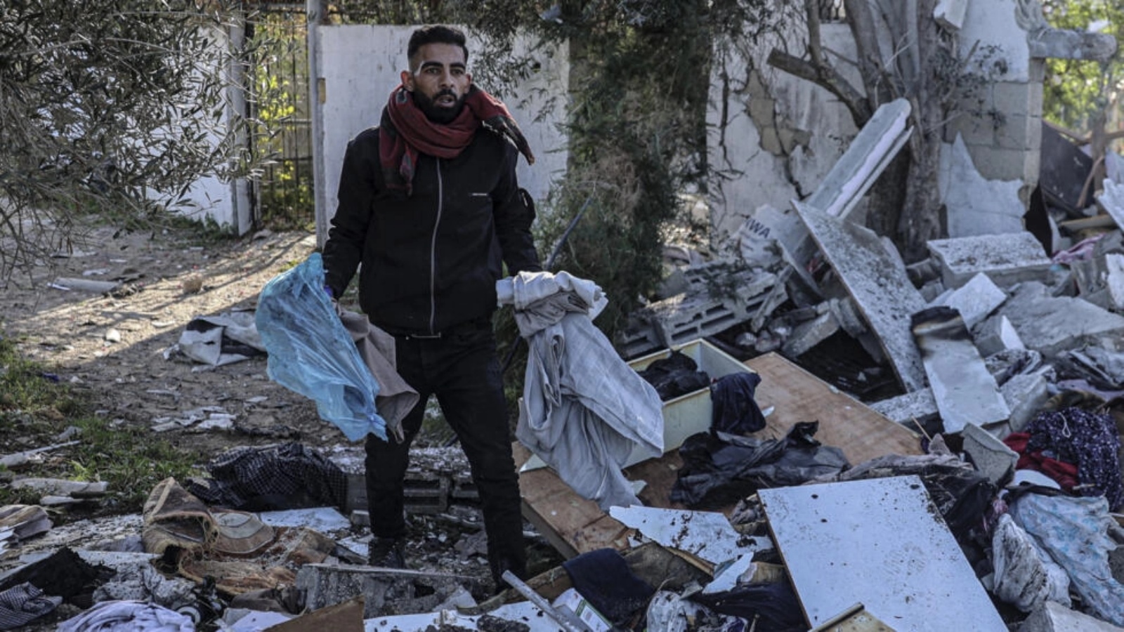فلسطيني يبحث عن متعلقاته وسط أنقاض منازل دمرها القصف الإسرائيلي في رفح بجنوب قطاع غزة في 11 آذار (مارس) 2024 