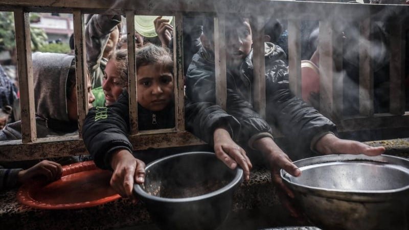 أطفال فلسطينيون نازحون يتجمعون للحصول على الطعام في مدرسة حكومية في رفح بجنوب قطاع غزة في 19 فبراير 2024