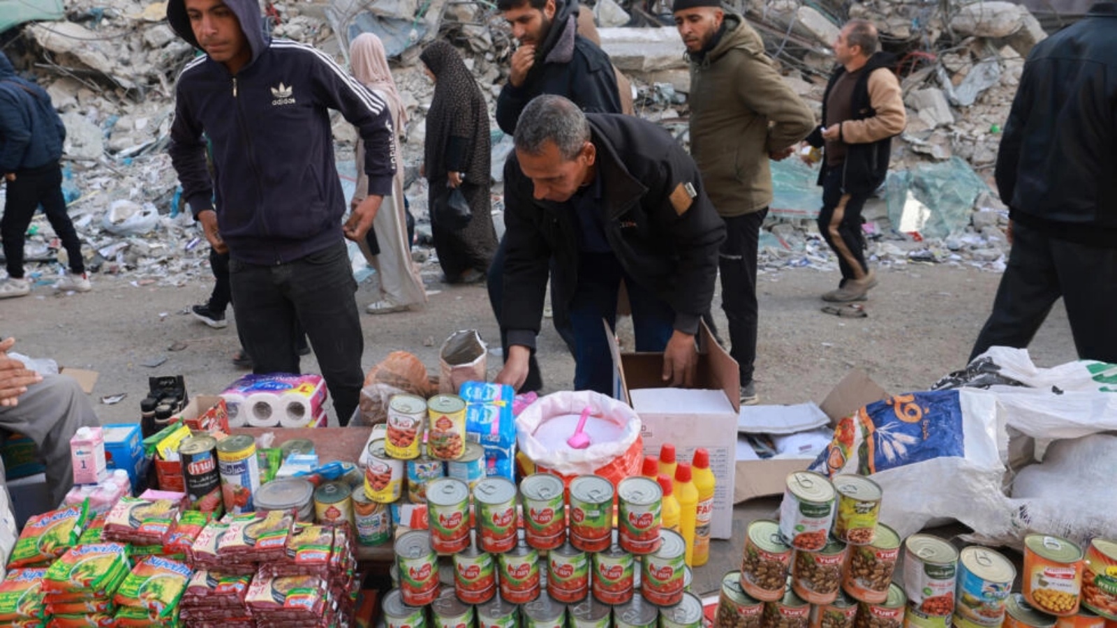 فلسطينيون يمرون أمام نصبات لبيع البضاعة اقيمت في أحد شوارع رفح جنوب قطاع غزة في 10 آذار (مارس) 2024، فيما يستعد المسلمون لشهر رمضان المبارك وسط المعارك المستمرة بين إسرائيل وحركة حماس الفلسطينية 