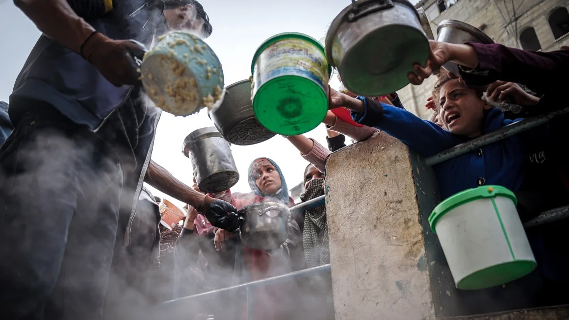 فلسطينيون ينتظرون لجمع الطعام عند نقطة تبرع في مخيم للاجئين في رفح