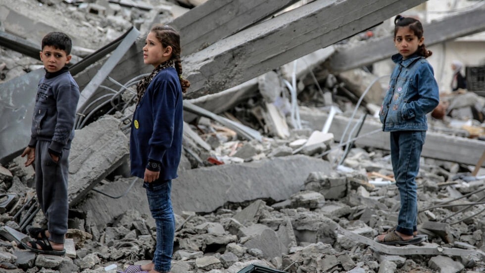 أطفال فلسطينيون وسط انقاض مبنى دمرته ضربة إسرائيلية في حي الرمال في غزة في 16 آذار/مارس 2024