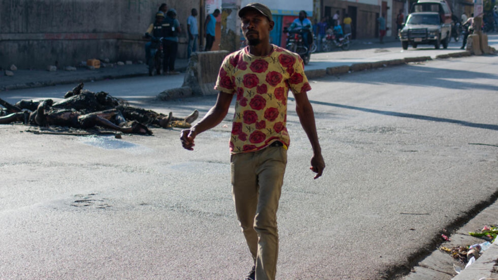 رجل يسير قرب جثث متفحمة في أحد شوارع هايتي في 22 آذار (مارس) 2024
