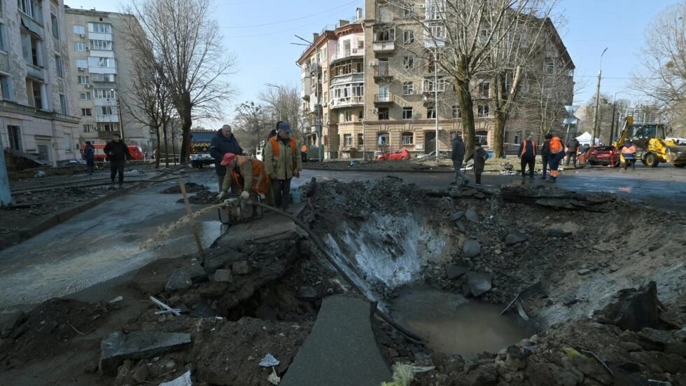 عمال بلدية يصلحون أضرارا ناجمة عن سقوط صاروخ في كييف في 21 آذار/مارس 2024