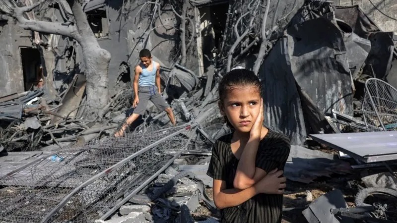 طفلة فلسطينية أمام أنقاض منزلها المدمر في مدينة غزة