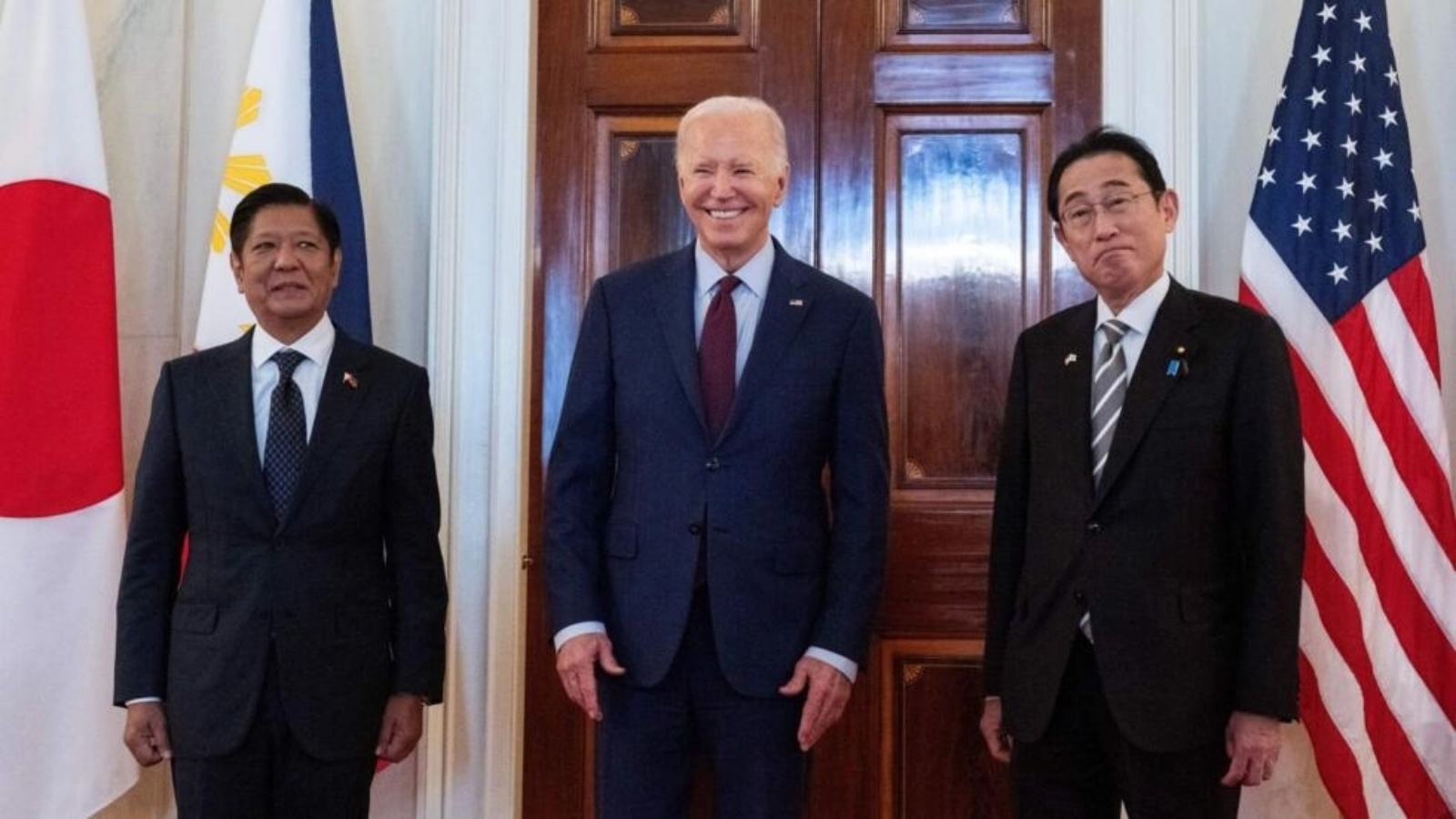 الرئيس الأميركي جو بايدن متحدثا للصحافة بين رئيس وزراء اليابان فوميو كيشيدا (يمين) ورئيس الفيليبين فرديناند ماركوس قبيل اجتماع ثلاثي في البيت الأبيض في 11 نيسان (أبريل) 2024 