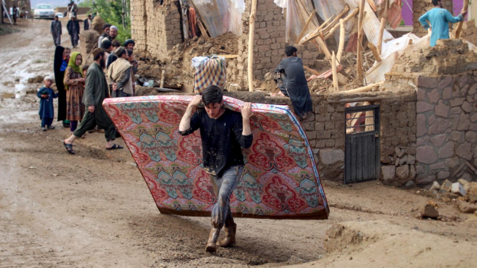 أفغان يجمعون حاجياتهم بعد تضرر مساكنهم جراء الفيضانات في ولاية غور في 18 أيار (مايو) 2024 