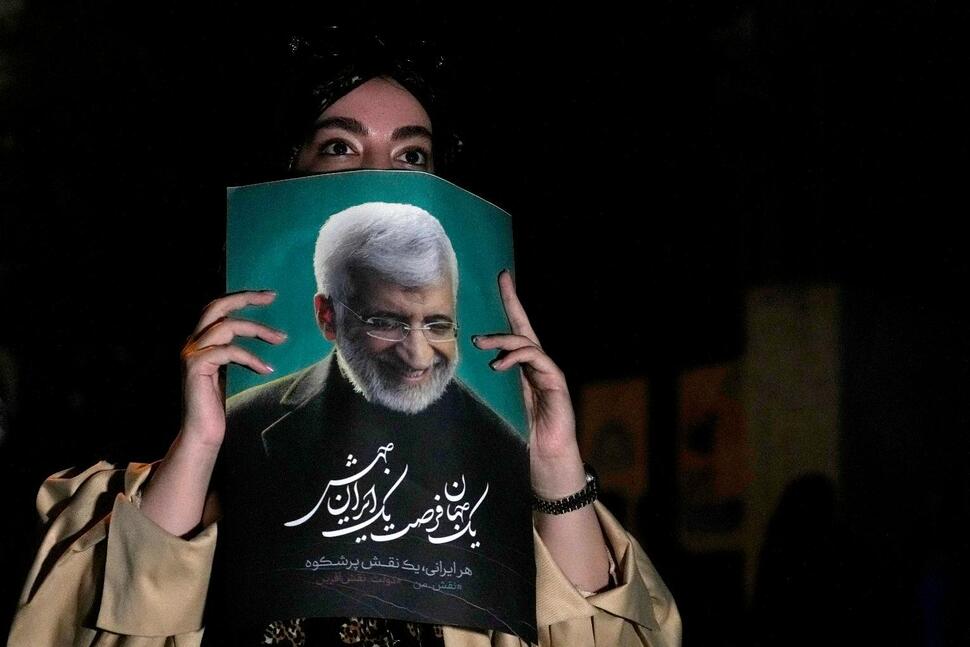 فتاة إيرانية من مؤيدات المرشح الرئاسي سعيد جليلي ترفع صورته
