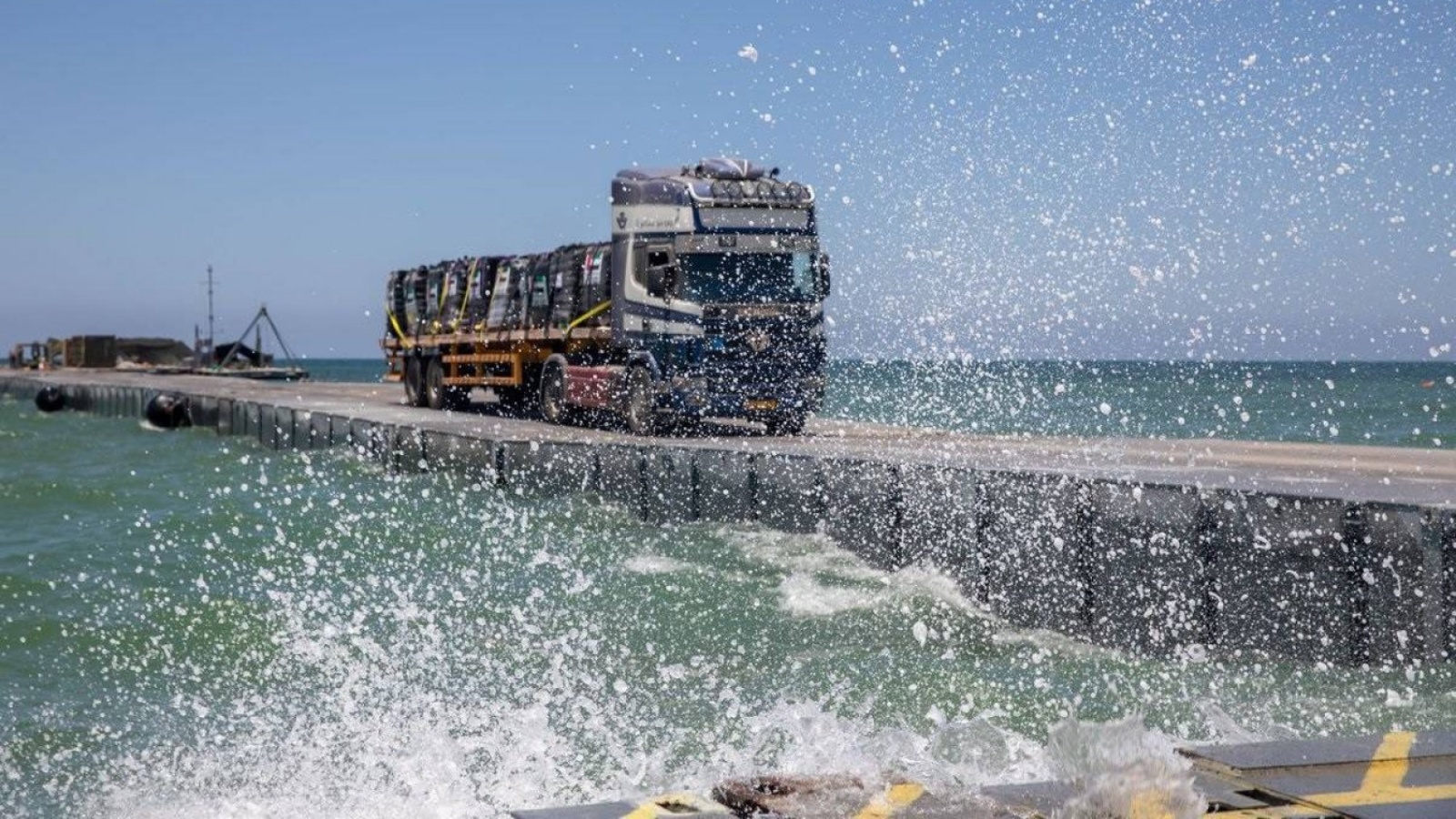 شاحنة مساعدات تعبر فوق الرصيف العائم قبالة سواحل غزة (حساب القيادة المركزية الأميركية على إكس) 