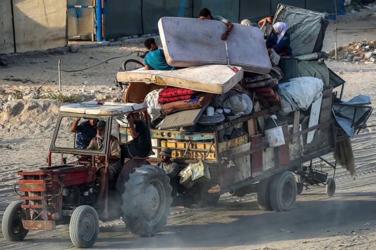 جرار يسحب عربةً تحمل أشخاصاً وأمتعتهم أثناء إجلائهم جنوباً من مدينة غزة في 2 سبتمبر/أيلول 2025.