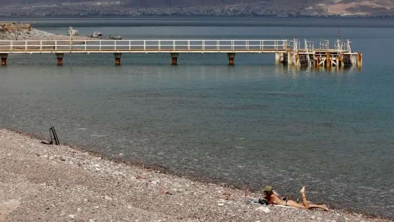 امرأة تستلقي على شاطئ البحر الأحمر في مدينة إيلات، جنوب إسرائيل