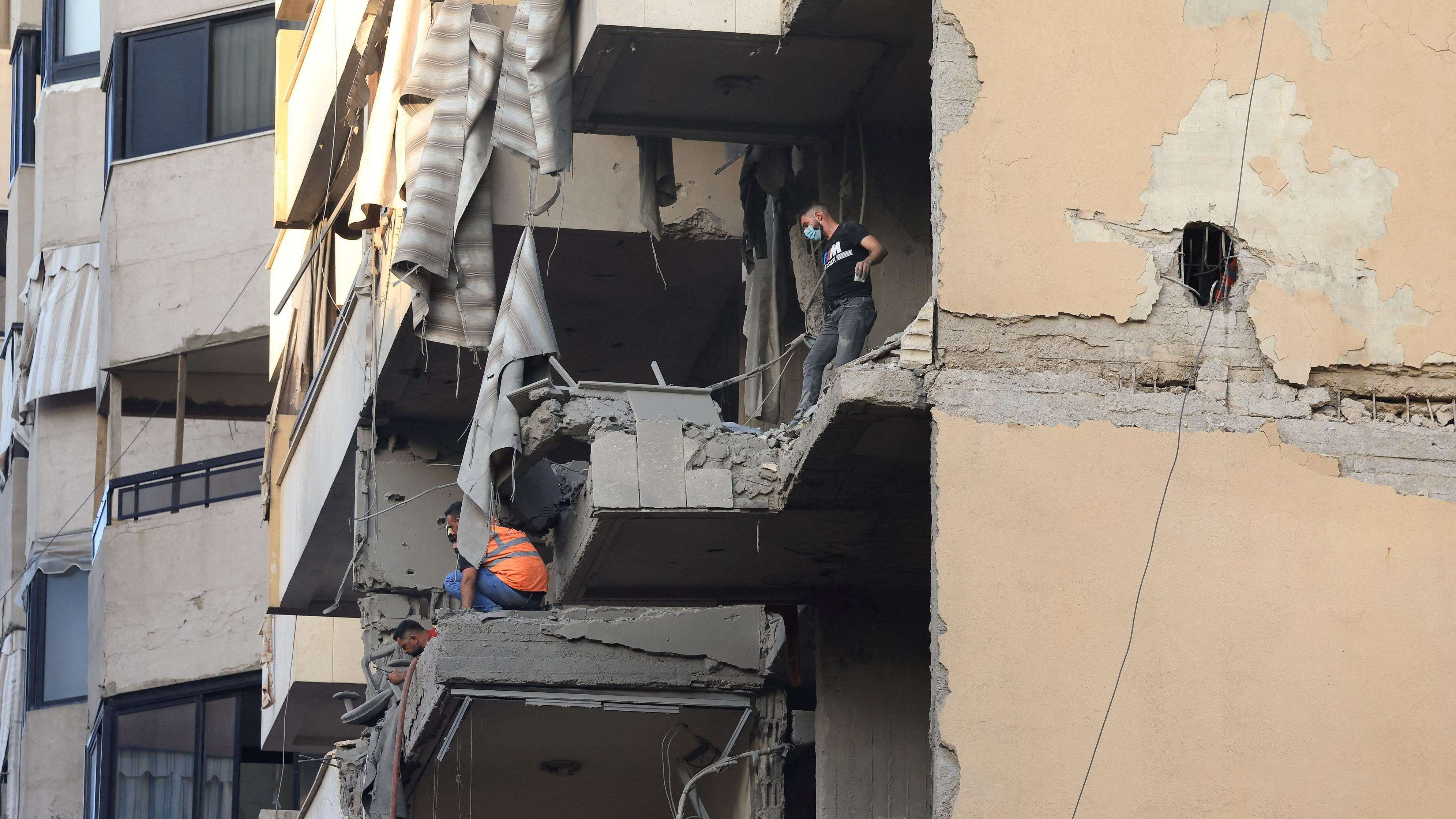 أشخاص يتفقدون مبنى متضرر، بعد هجوم إسرائيلي على الضاحية الجنوبية لبيروت، 23 نوفمبر/تشرين الثاني 2025 - Reuters