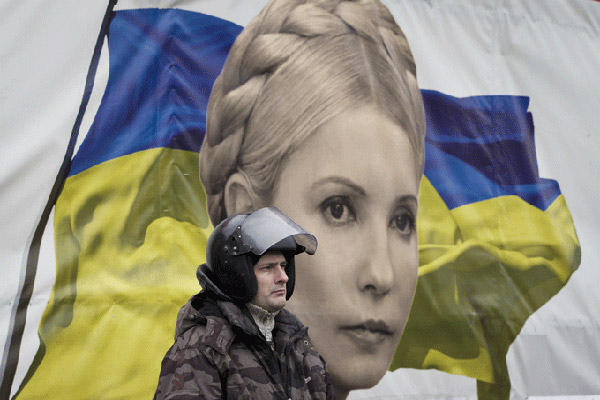 شرطي أوكراني يمر من أمام ملصق ضخم لتيموشينكو