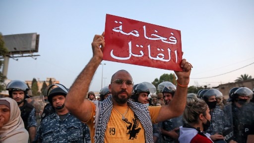 متظاهر لبناني يحمل لافتة كتب عليها 