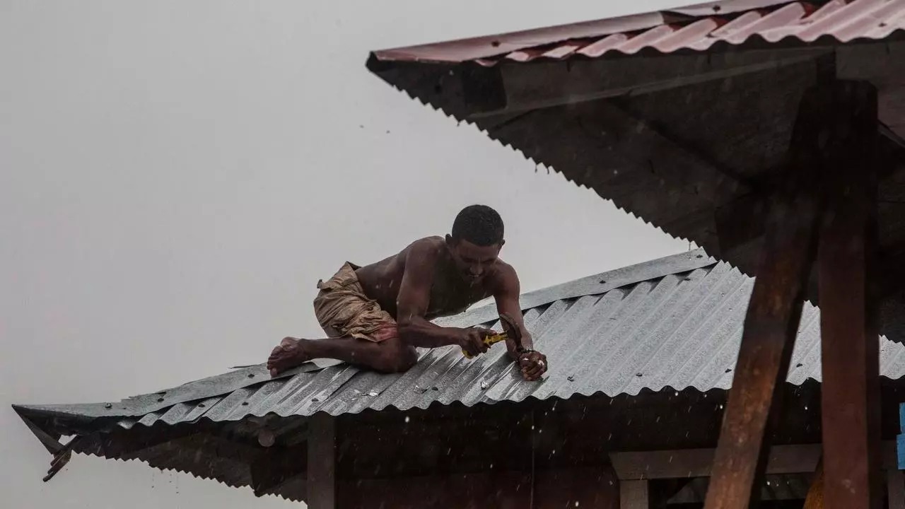 رجل يثبّت سقف منزله في بيلوي في نيكاراغوا في 16 نوفمبر تحسّباً لوصول الإعصار أيوتا