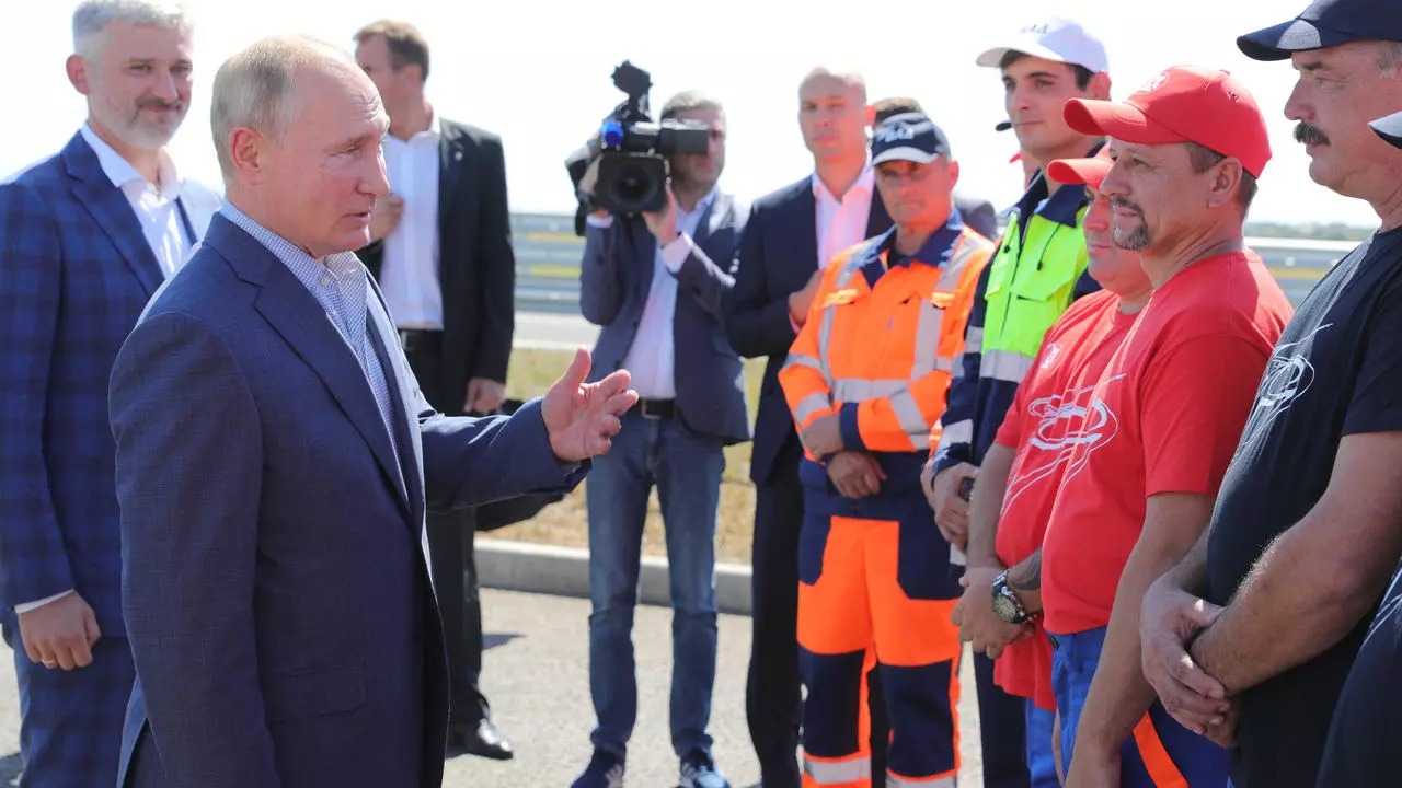 بوتين (الثاني من اليسار) برفقة وزير النقل يفغيني ديتريخ (إلى اليسار) يلتقي بعمال الطرق خلال مراسم تدشين طريق تافريدا الفيدرالي السريع في القرم. 27 أغسطس 2020