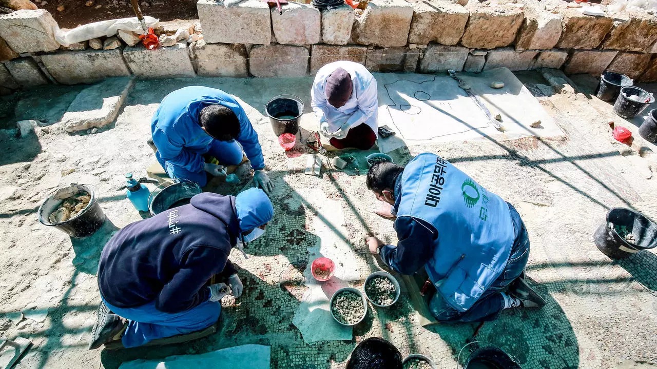 عمال يرممون أرضية فسيفساء في رحاب في شمال الأردن في التاسع من فبراير 2021
