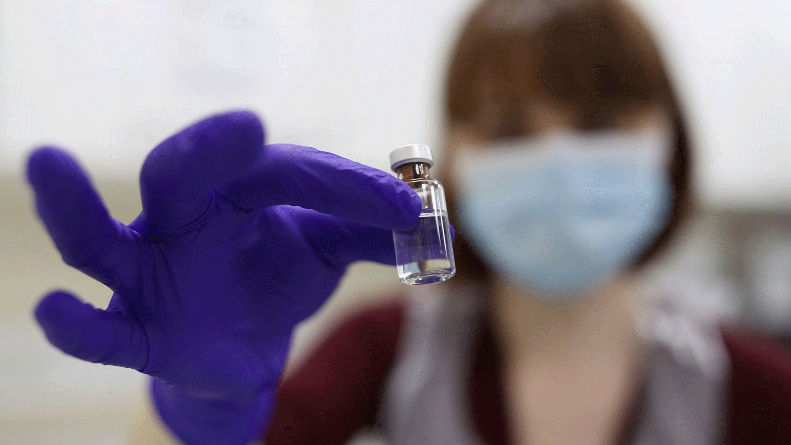 أخصائية صيدلية تابعة لهيئة الخدمات الصحية الوطنية تحمل قارورة لقاح فيروس كورونا في مستشفى رويال فري بلندن، 4 كانون الأول/ديسمبر 2020