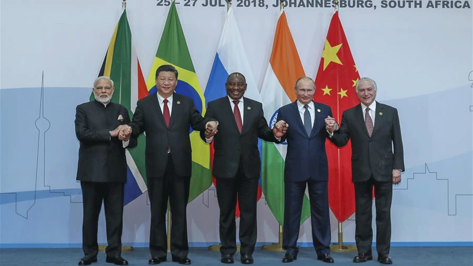 صورة أرشيفية تُظهر الرئيس الصيني شي جين بينغ (الثاني من اليسار) والرئيس البرازيلي(آنذاك) ميشيل تامر (الأول إلى اليمين) والرئيس الروسي فلاديمير بوتين (الثاني إلى اليمين) ورئيس الوزراء الهندي ناريندرا مودي (الأول من اليسار) ورئيس جنوب أفريقيا سيريل رامافوزا في صورة جماعية خلال الجلسة العامة الدورة العاشرة لقمة البريكس في جوهانسبرغ، جنوب أفريقيا. 26 تموز\ يوليو 2018 (شينخوا)