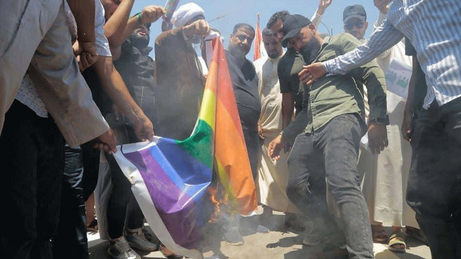 متظاهرون عراقيون ضد الشذوذ الجنسي يحرقون في النجف في في 3 يونيو\حزيران 2023 علم المثليين (تويتر)