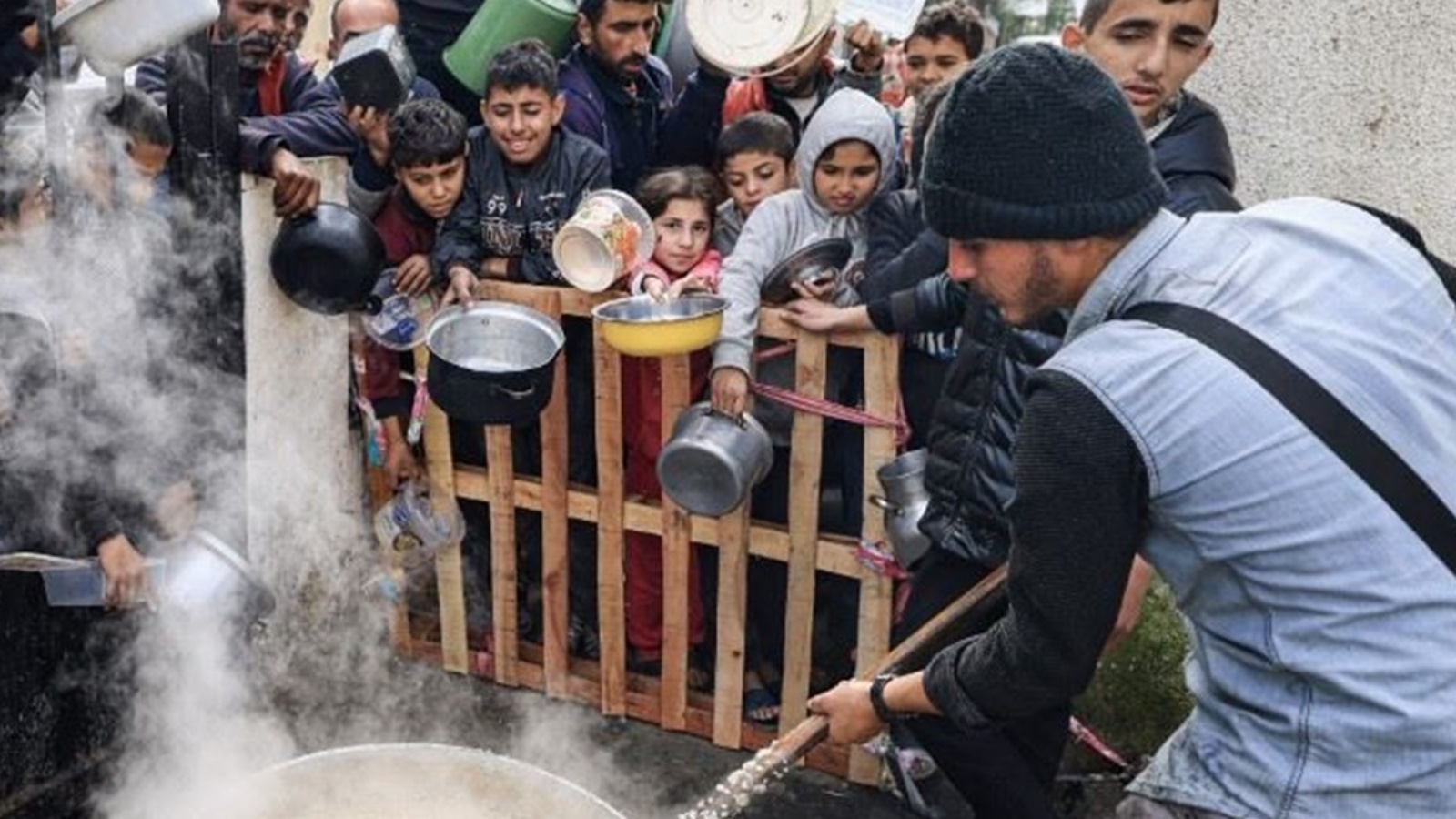 فلسطينيون ينتظرون للحصول على حصة غذائية في مخيم برفح