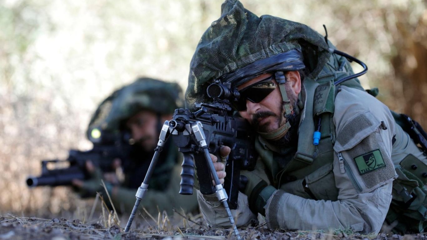 جندي إسرائيلي يحتفظ بموقعه بينما تتدرب القوات في منطقة الجليل الأعلى بالقرب من الحدود مع لبنان