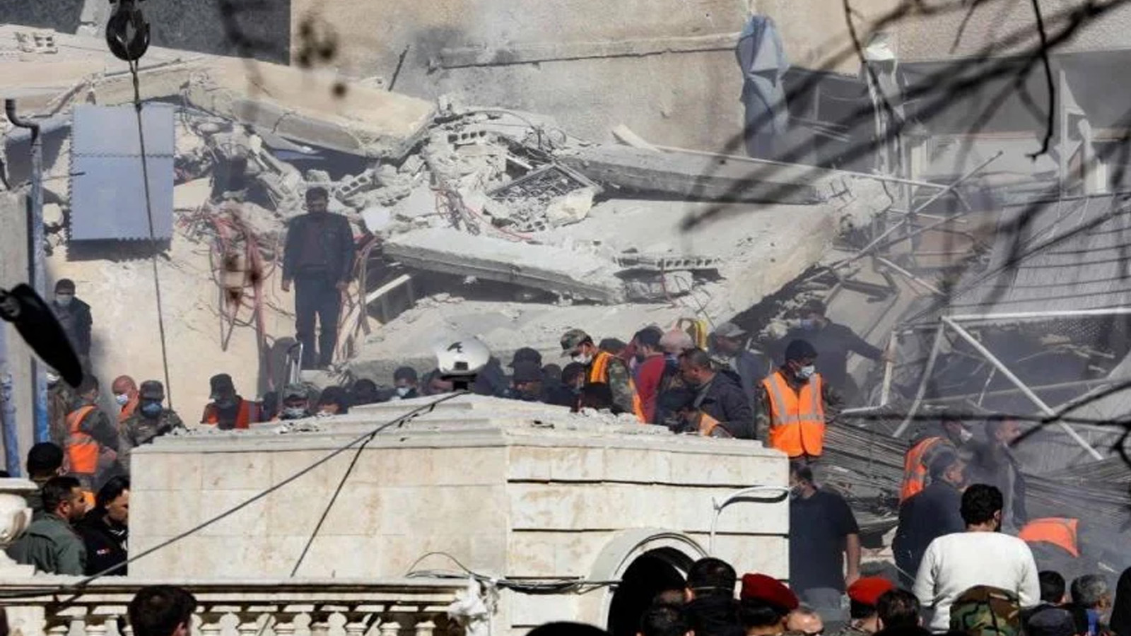 أشخاص وعمال إنقاذ يتجمعون أمام مبنى دمر جراء غارة إسرائيلية في دمشق