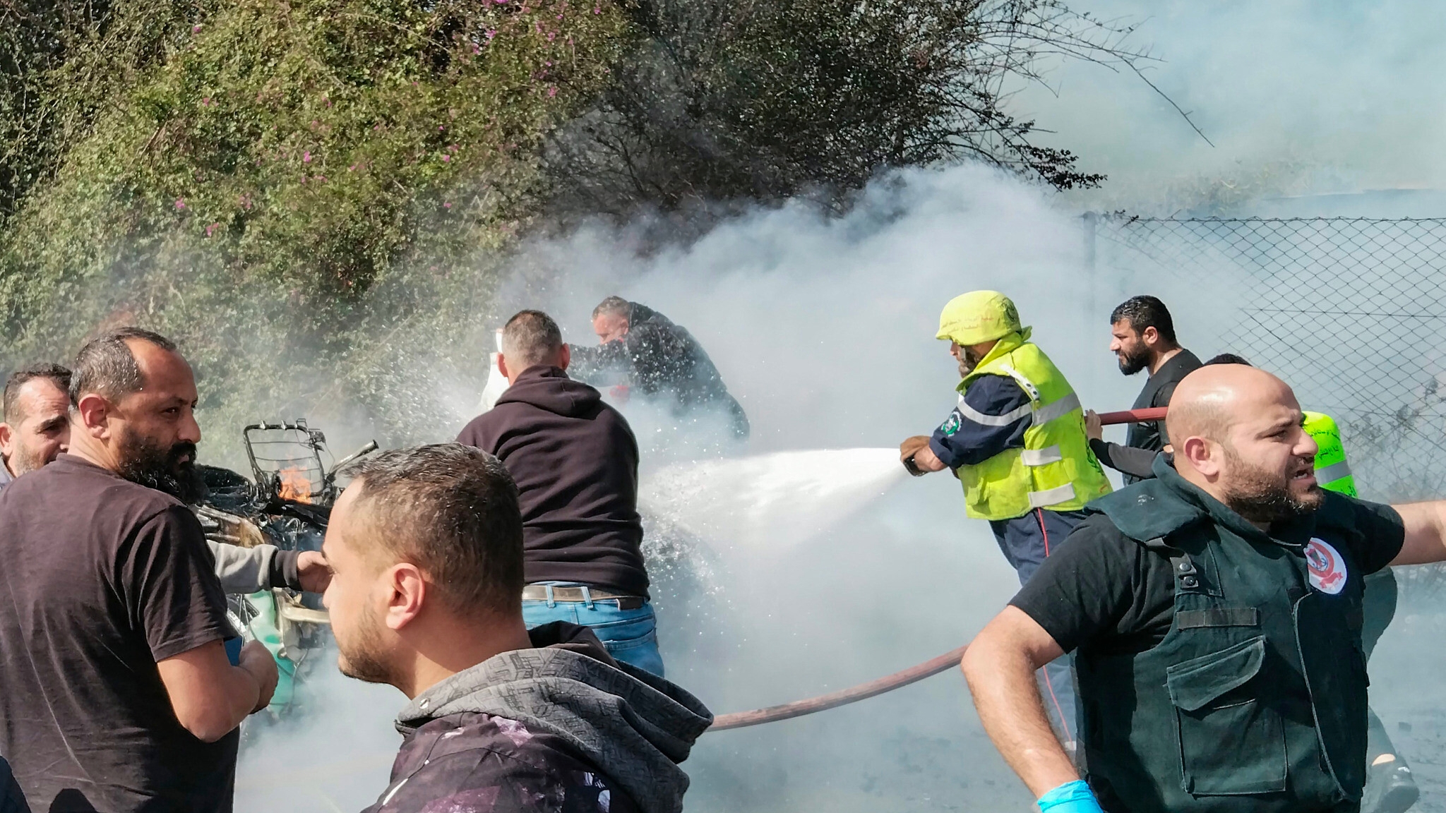 رجال الإطفاء يكافحون ألسنة اللهب بعد استهداف إسرائيل سيارة في صور في 13 آذار (مارس) 2024