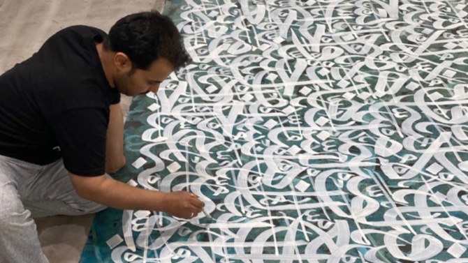 الفنان السعودي خالد المطلق ينكب على إنجاز عمل فني يتكيء على جماليات الحرف العربي