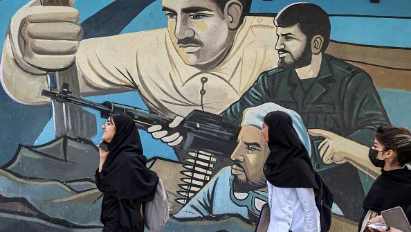 نساء يسرن بالقرب من جدارية مناهضة لإسرائيل في طهران
