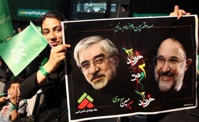 فتاة إيرانية تحمل صورة تجمع مير حسين موسوي ومحمد خاتمي