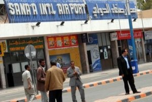 رجال يقفون أمام مطار صنعاء في اليمن