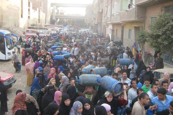 مصريات في منطقة شعبية يحاولن تعبئة أنابيب الغاز