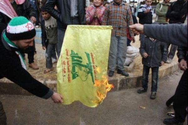 معارضو النظام السوري يحرقون علم حزب الله اللبناني