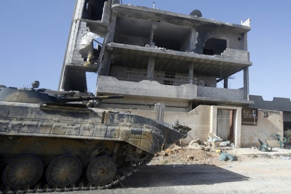 دبابة سورية في القصير حيث آثار الدمار في المدنية واضحة نتيجة المعارك هناك -أ ف ب 