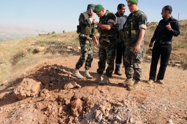 جنود لبنانيون يعاينون آثار حفرة أحدثها صاروخ أطلق من سوريا على منطقة البقاع