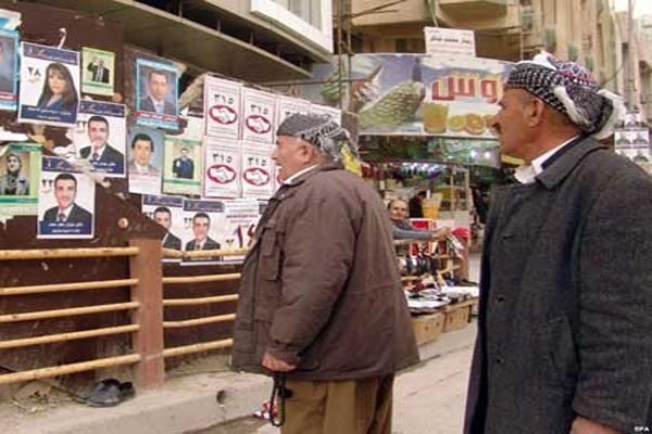 كرديان عراقيان يطّلعان على صور وبرامج مرشحين لانتخابات برلمان الإقليم