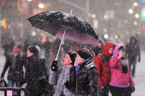 زوار يتمتعون بالثلوج في تايمز سكوير في نيويورك