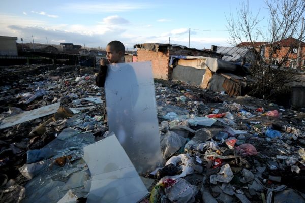 صبي يقف وسط كومة من القمامة في مستوطنة فاكولتيتا في صوفيا، بلغاريا