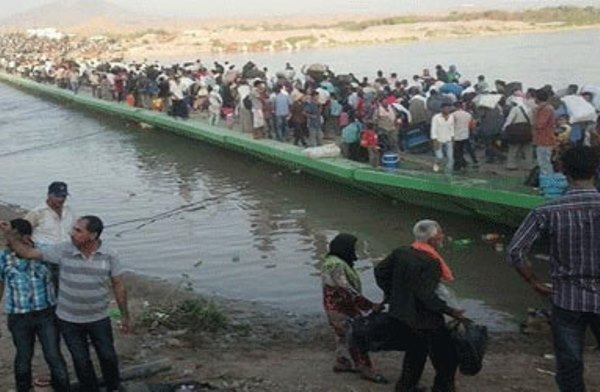 لاجئون سوريون يعبرون جسر فيشخابور إلى اقليم كردستان العراق