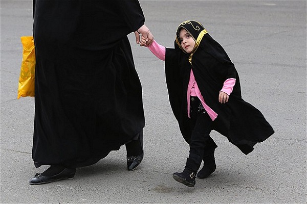 أم عراقية تصطحب ابنتها الصغيرة في أحد شوارع بغداد
