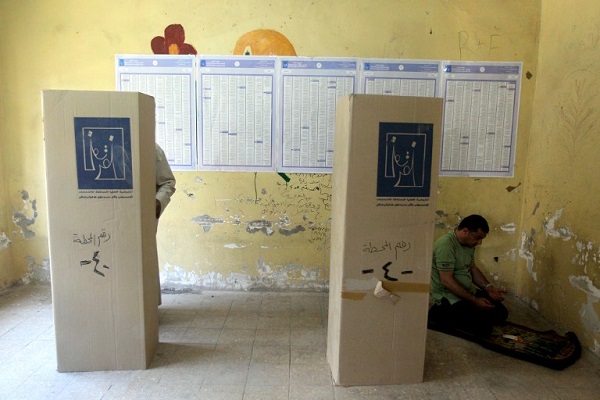 موظف في لجنة الانتخابات يصلي قبل بدء الاقتراع - أ.ف.ب